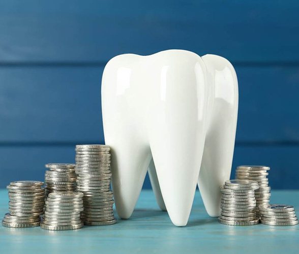 A giant ceramic tooth surrounded by silver coins on a blue background