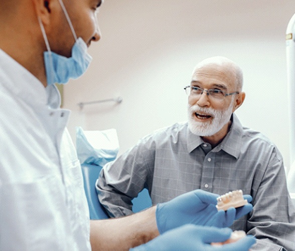 senior man at a consultation for implant dentures