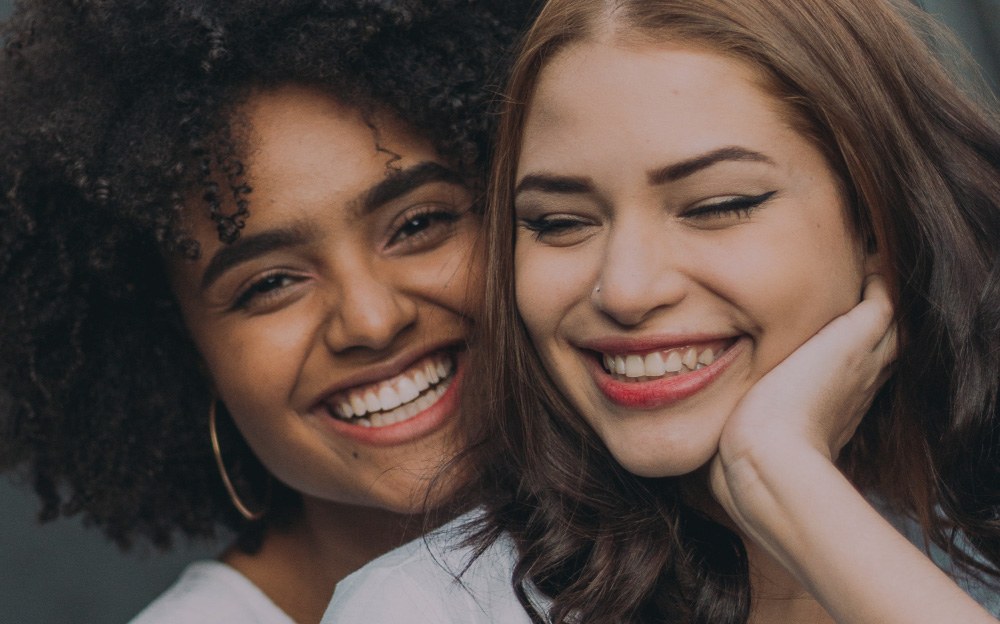 Two women smiling after emergency dentistry